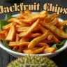 A bowl of crispy jackfruit chips with fresh jackfruit slices and green leaves.