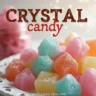 Colorful crystal candy displayed on a decorative plate, showcasing sparkling sugar crystals in various shapes.